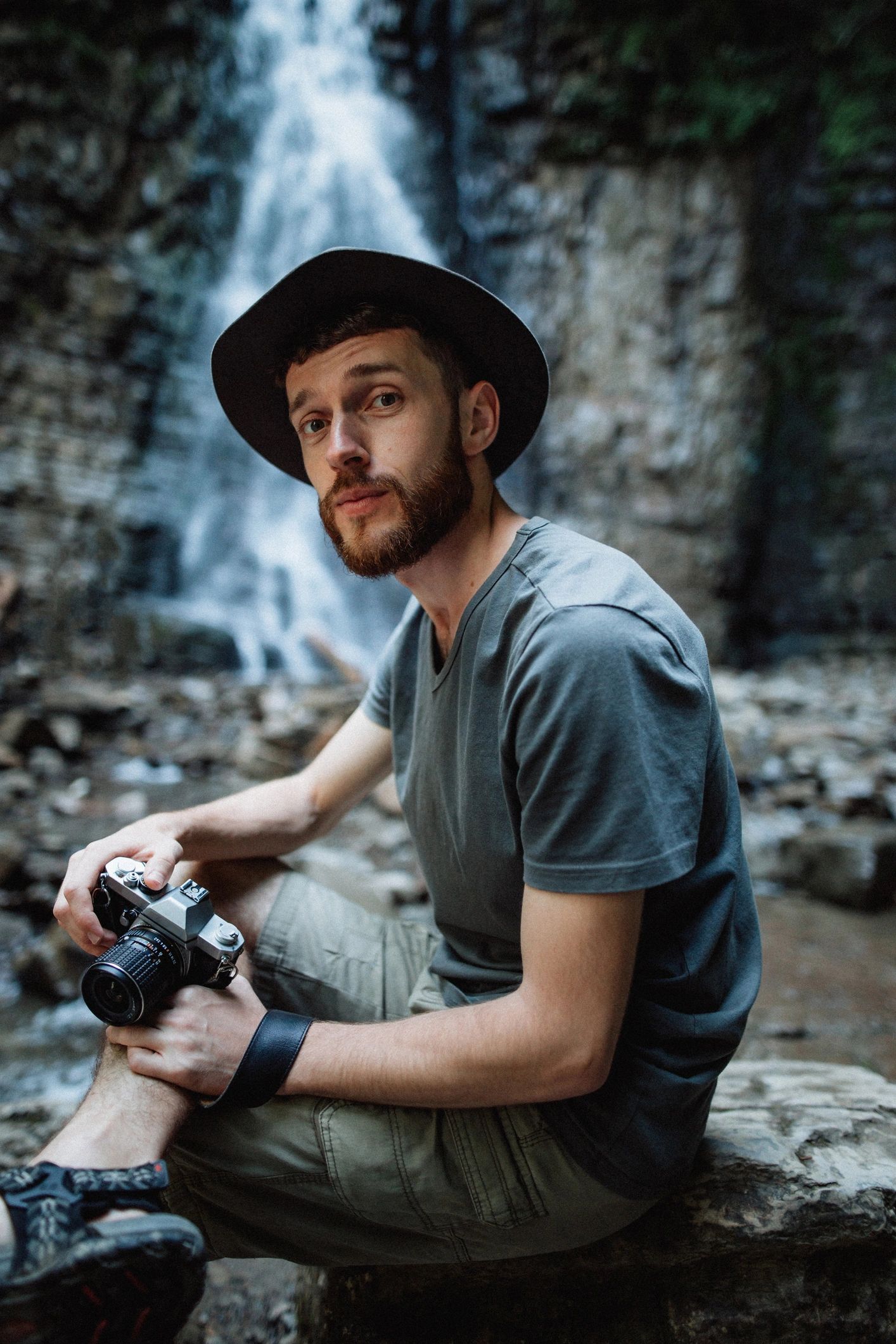 Traveler with camera near a waterfall