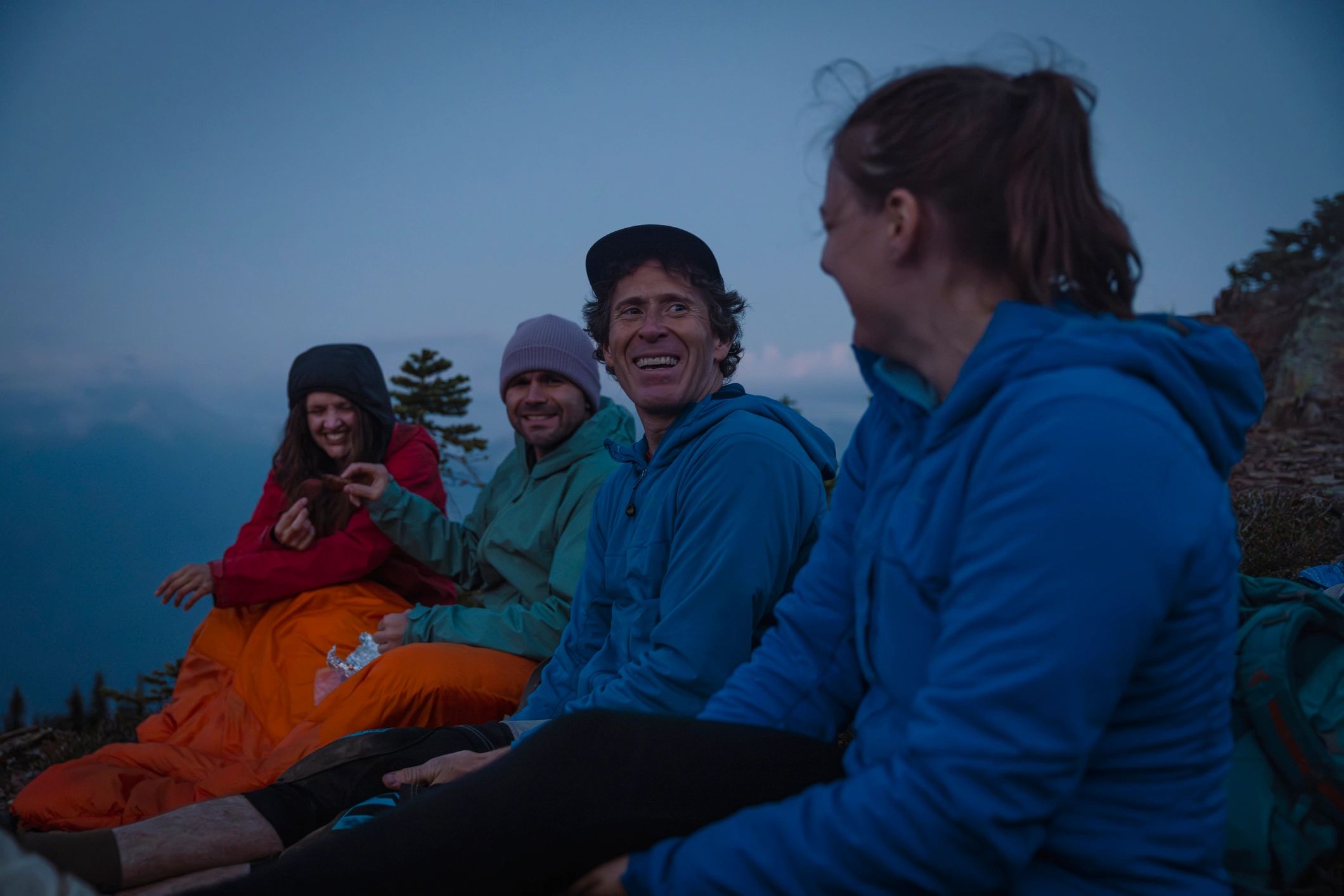 Backpackers relaxing on mountain top at twilight