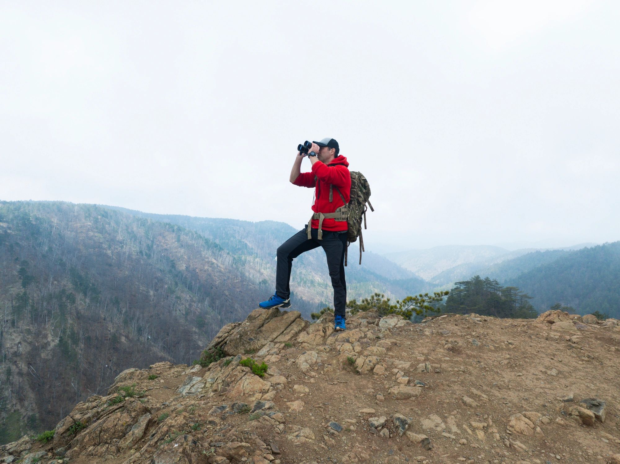 Hiker standing near a massive mountain cliff edge